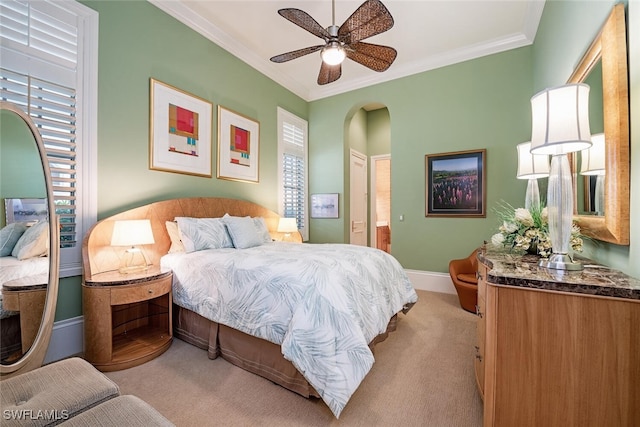 carpeted bedroom with ornamental molding and ceiling fan