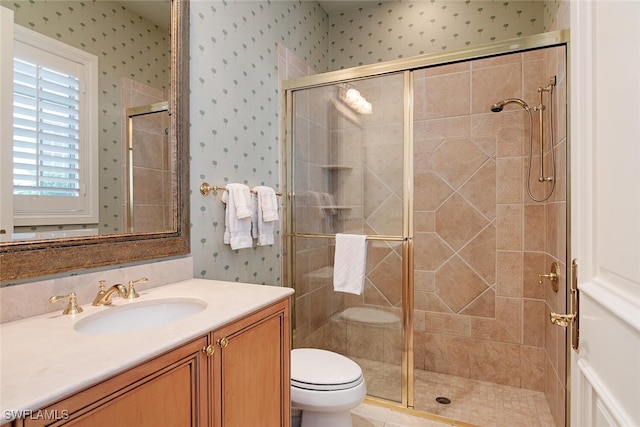 bathroom with toilet, an enclosed shower, and vanity