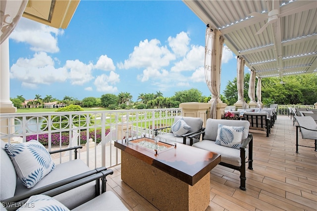 view of patio / terrace with ceiling fan and an outdoor living space with a fire pit