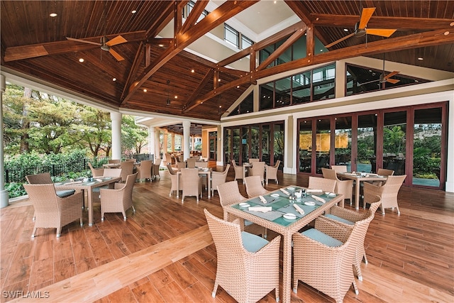 sunroom with ceiling fan, wooden ceiling, and vaulted ceiling with beams