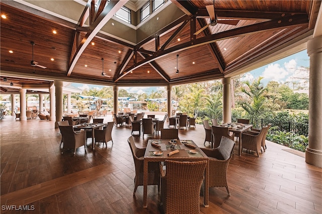 exterior space featuring wood-type flooring, decorative columns, wooden ceiling, high vaulted ceiling, and beam ceiling