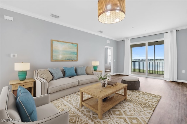 living room featuring crown molding, hardwood / wood-style floors, and a water view