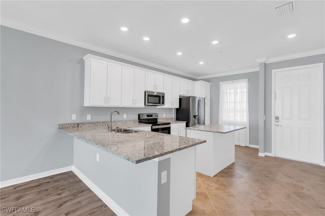 kitchen with kitchen peninsula, stainless steel appliances, and white cabinets