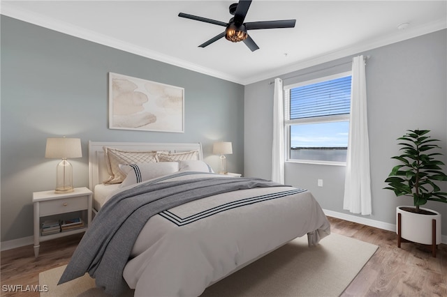 bedroom with ceiling fan, light wood-type flooring, and crown molding