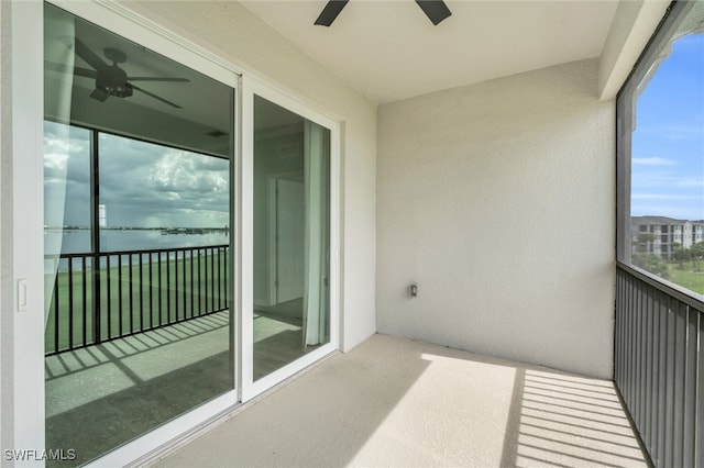 balcony with a water view and ceiling fan