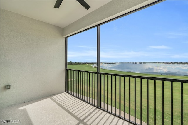 unfurnished sunroom with a water view and ceiling fan