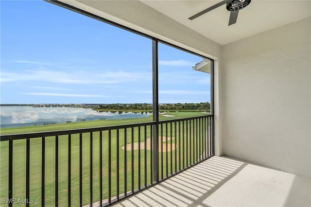 unfurnished sunroom featuring ceiling fan and a water view