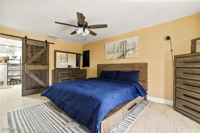 bedroom featuring a barn door and ceiling fan