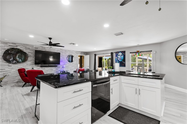 kitchen with dishwasher, light hardwood / wood-style flooring, sink, a kitchen bar, and white cabinets