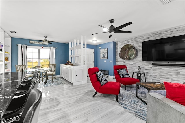 living room with light wood-type flooring and ceiling fan