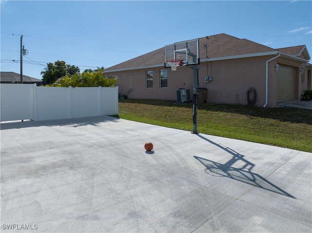 view of sport court featuring a lawn