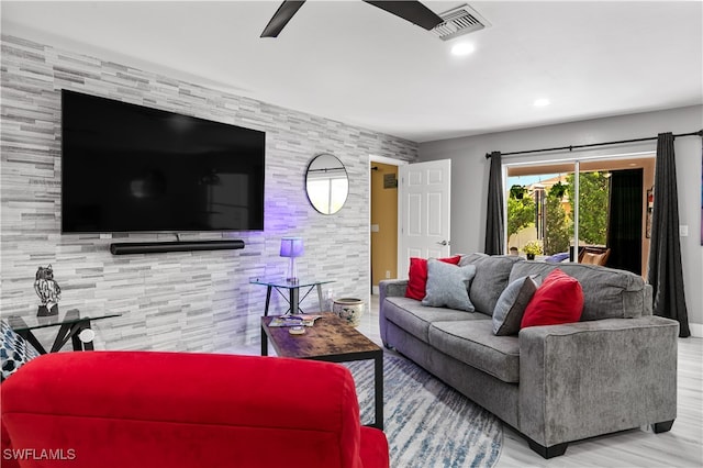 living room with light hardwood / wood-style floors and ceiling fan