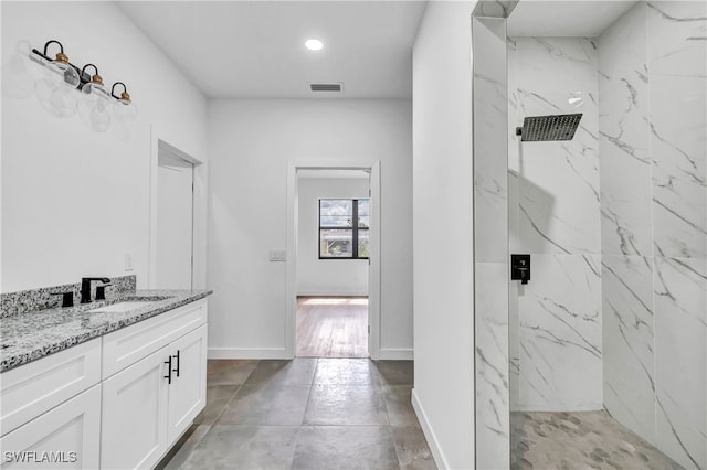 bathroom with vanity and tiled shower