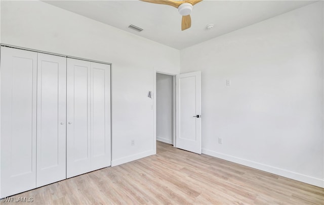 unfurnished bedroom with ceiling fan, light wood-type flooring, and a closet