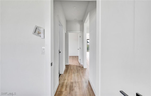 corridor with light hardwood / wood-style flooring