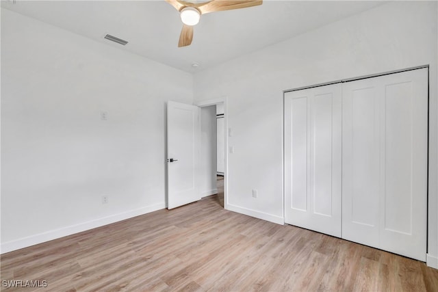 unfurnished bedroom featuring ceiling fan, light hardwood / wood-style floors, and a closet