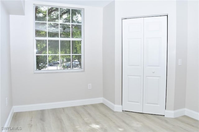 unfurnished bedroom featuring a closet and light wood-type flooring