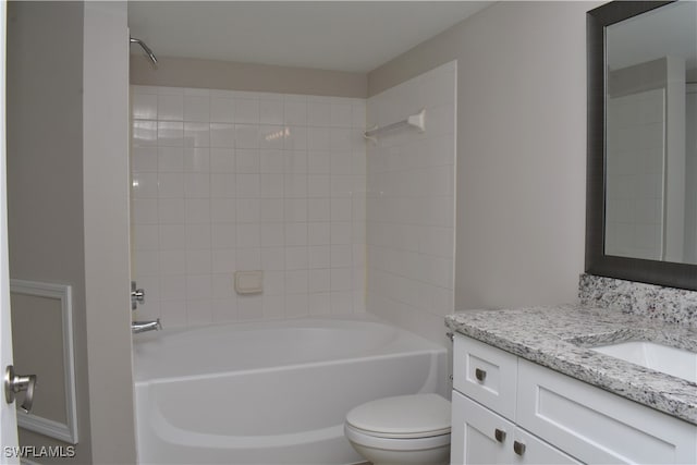 full bathroom with tiled shower / bath, vanity, and toilet