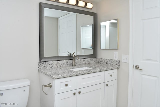 bathroom featuring vanity and toilet