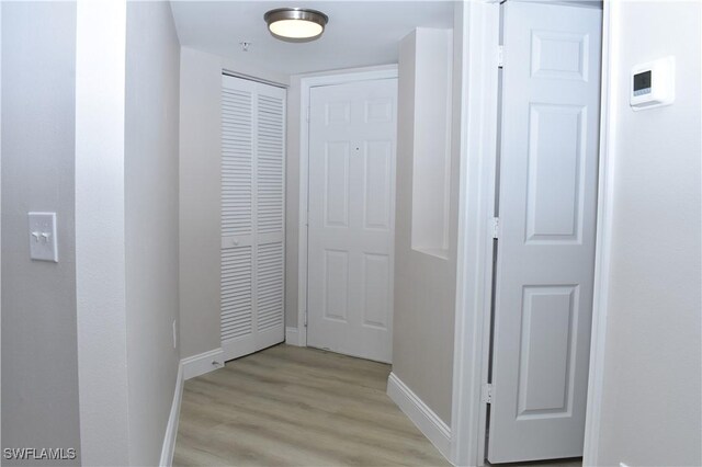 corridor with light hardwood / wood-style flooring