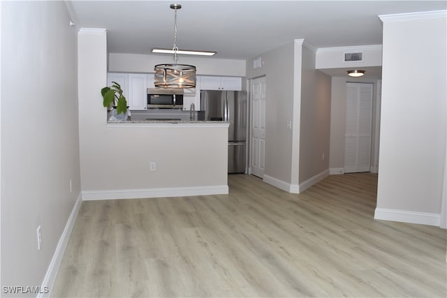 kitchen featuring white cabinets, stainless steel appliances, light wood-type flooring, and crown molding