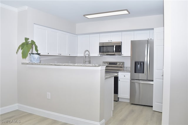 kitchen featuring white cabinetry, light hardwood / wood-style floors, kitchen peninsula, stainless steel appliances, and light stone countertops