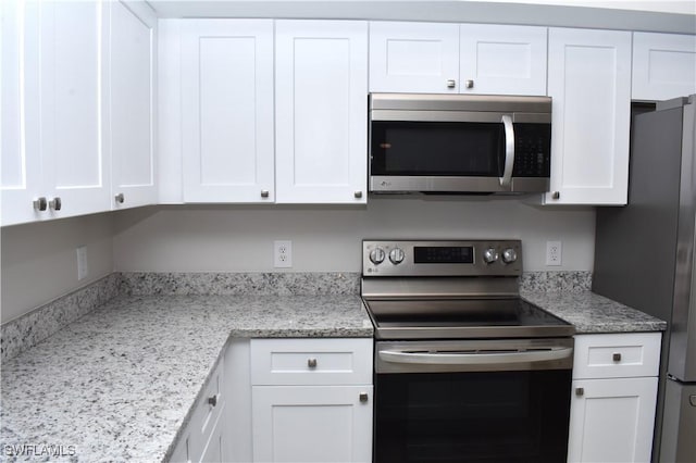 kitchen featuring white cabinets, appliances with stainless steel finishes, and light stone countertops