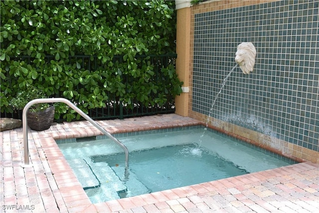 view of swimming pool featuring an in ground hot tub