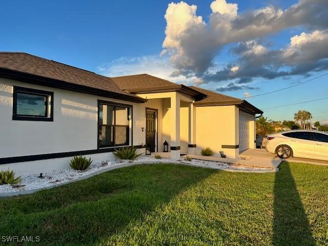 exterior space featuring a garage and a lawn