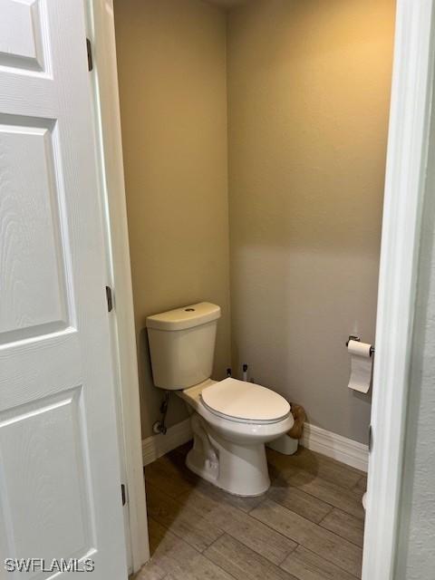 bathroom with hardwood / wood-style flooring and toilet