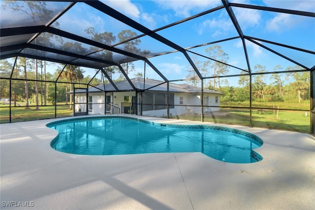 view of pool with glass enclosure and a patio