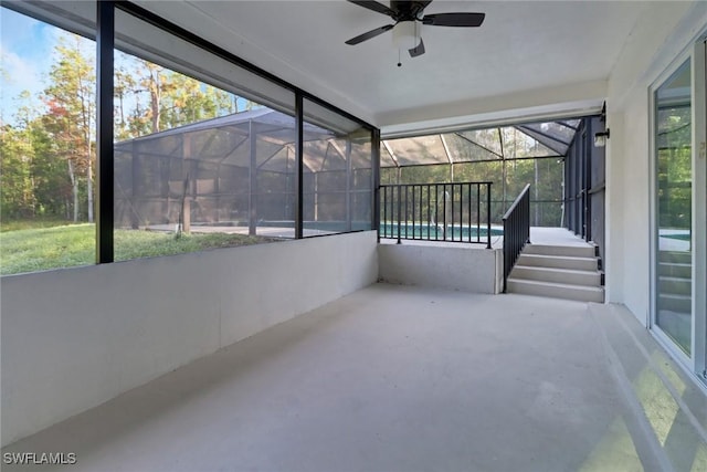 unfurnished sunroom featuring a wealth of natural light and ceiling fan