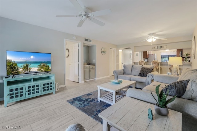 living room featuring ceiling fan and light hardwood / wood-style flooring