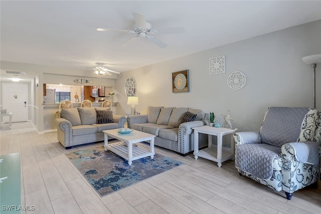 living room featuring ceiling fan and light wood-type flooring