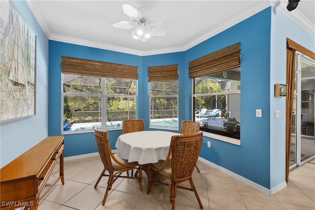 tiled dining space with ceiling fan, plenty of natural light, and ornamental molding