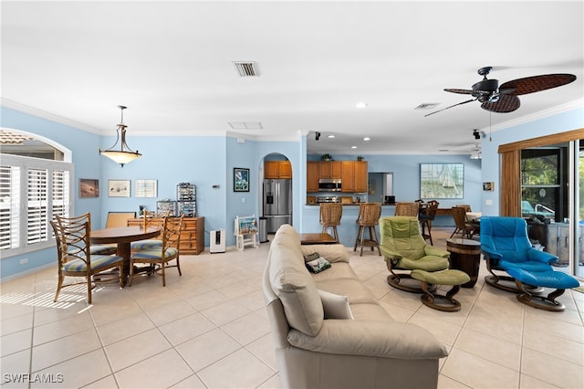 living room featuring ceiling fan, light tile patterned floors, and crown molding