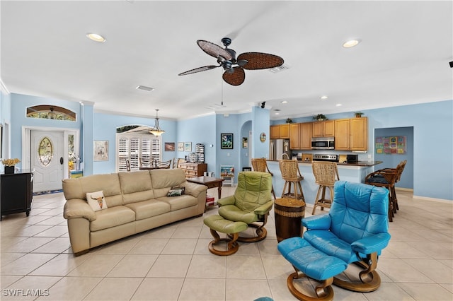 living room featuring light tile patterned floors, ceiling fan, and crown molding