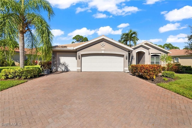 view of front of property with a garage, decorative driveway, and stucco siding