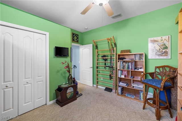 living area with light carpet and ceiling fan