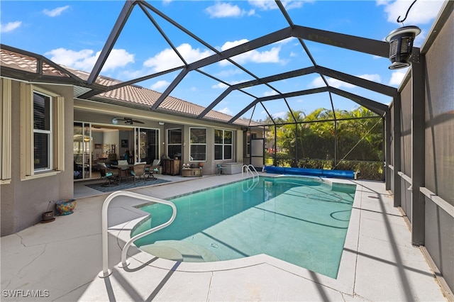 view of swimming pool featuring a patio area, ceiling fan, and a lanai