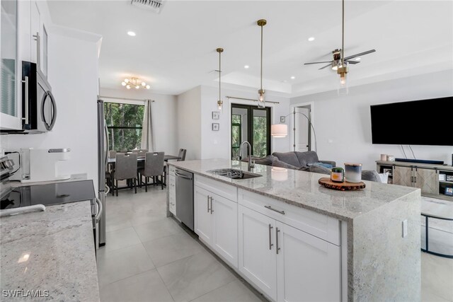 kitchen featuring ceiling fan, white cabinets, stainless steel appliances, and a wealth of natural light