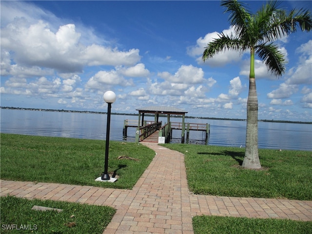 dock area featuring a lawn and a water view