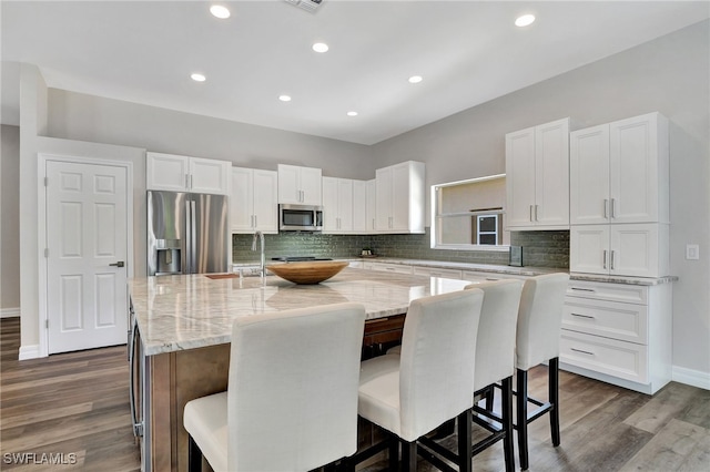 kitchen featuring a center island, stainless steel appliances, and a breakfast bar