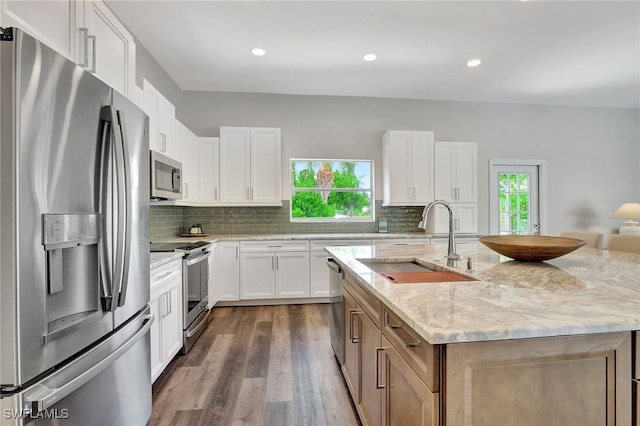 kitchen featuring white cabinets, appliances with stainless steel finishes, sink, and a wealth of natural light