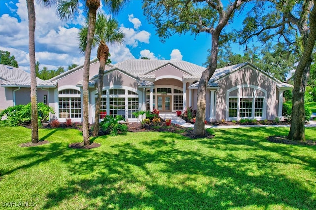 rear view of house with a lawn and french doors