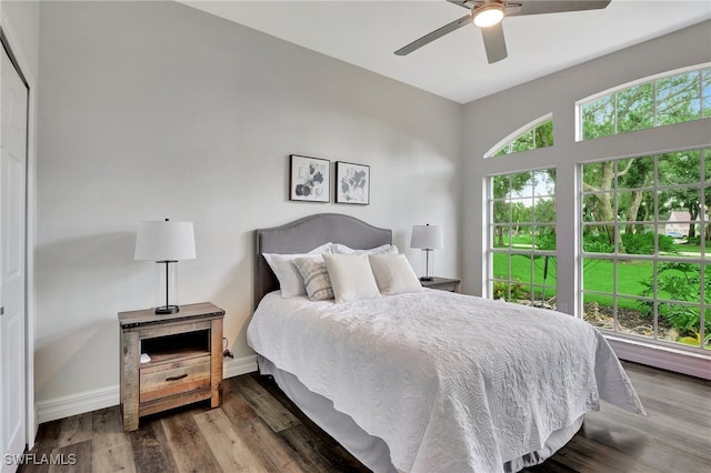 bedroom with ceiling fan, vaulted ceiling, a closet, and hardwood / wood-style floors