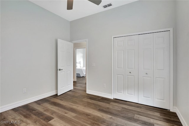 unfurnished bedroom with ceiling fan, a closet, and dark wood-type flooring