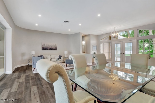 dining area featuring lofted ceiling, a chandelier, hardwood / wood-style flooring, and french doors