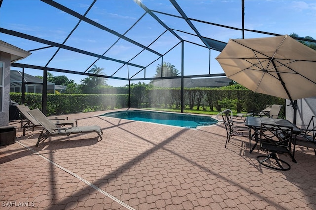 view of pool featuring glass enclosure and a patio area