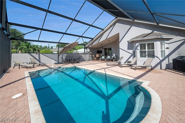 view of pool with glass enclosure and a patio